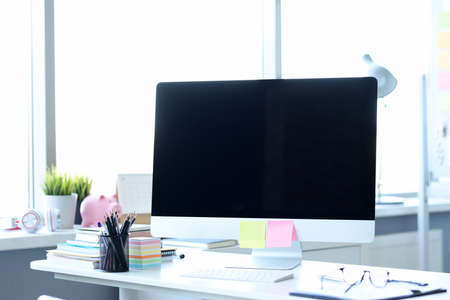 Computer with multicolored stickers standing on desktop in officeの写真素材