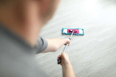 Man washing floor of house with mop closeupの写真素材