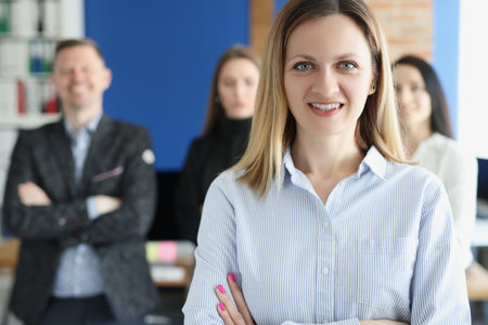 Portrait of young successful business woman on background of colleaguesの写真素材