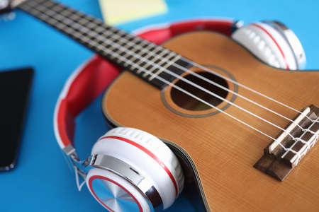 Acoustic guitar with headphones lies on tableの写真素材