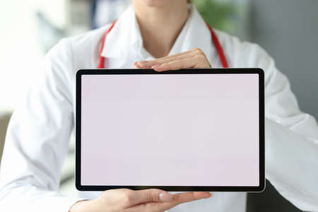 Female doctor is holding tablet with white screenの写真素材
