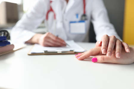 Doctor hand rests on patient hand, psychological support is providedの写真素材