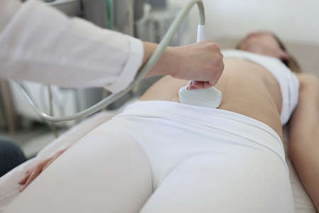 Doctor doing ultrasound scan of fetus to patient closeupの写真素材
