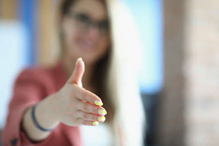 Businesswoman stretches out her hand for handshakeの写真素材