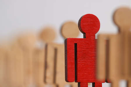 Wooden figures of people, one of them is redの写真素材