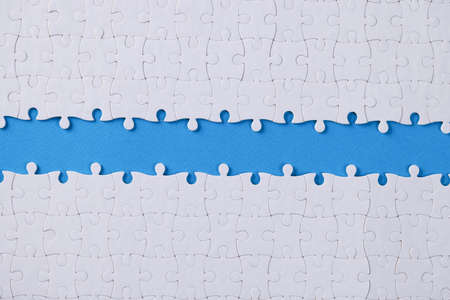 Unassembled white puzzle in middle on dove backgroundの写真素材