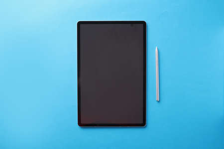 Modern touch tablet with stylus lies on blue backgroundの写真素材