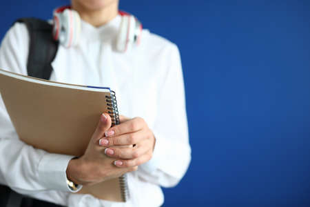 Silhouette of woman with backpack and headphones in hands of notebook