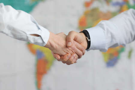 Business people handshake on background of world map of worldの写真素材