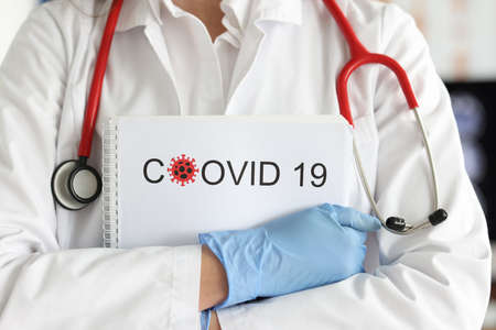 Gloved doctor holds documents with statistics of cases of coronavirus infectionの写真素材