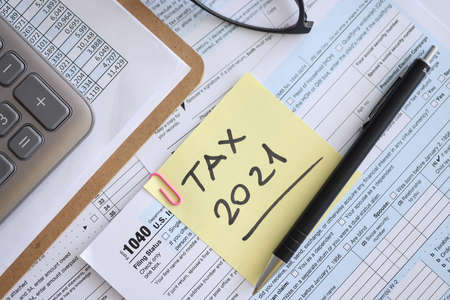 Tax form for 2021 with pen and report is on table