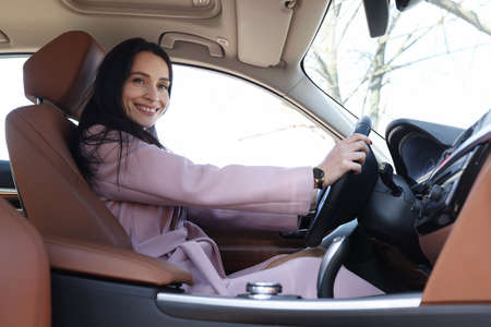 Young smiling woman driving luxury car closeupの写真素材