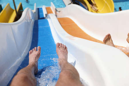 Male feet on slide in a water park while descendingの写真素材