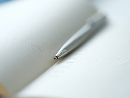 Ballpoint metal pen lying on open diary closeupの写真素材
