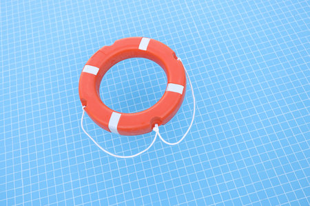 Orange lifebuoy lying on water in swimming pool closeup
