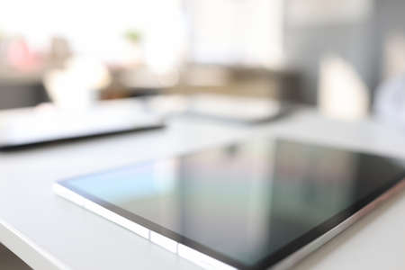 Modern digital tablet lies on table in backgroundの写真素材