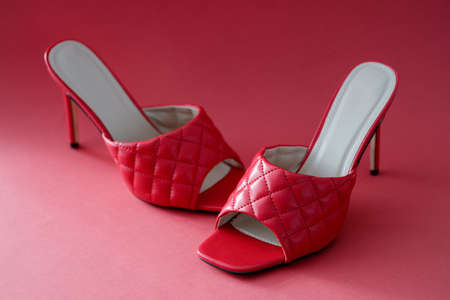 Women high heeled sandals standing on red background closeupの写真素材