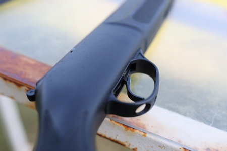 black firearm with trigger lies on table closeupの写真素材