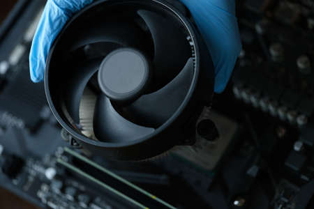 Gloved craftsman installing cooler into video card closeupの写真素材
