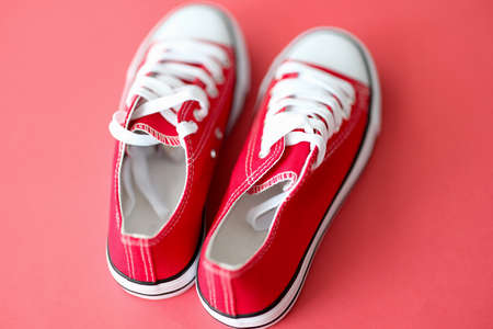 Red sneakers with white laces against red background closeupの写真素材
