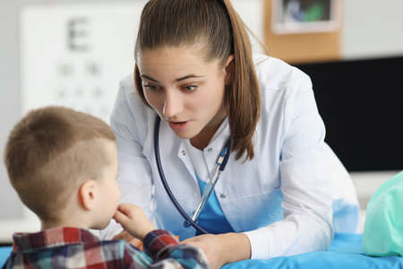 Little boy sitting at appointment of woman pediatrician in clinicの写真素材
