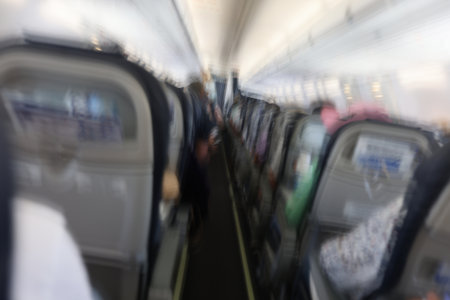 Passengers flying in aircraft cabin back view blurred background