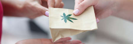 Handing over paper bag with marijuana sign.の写真素材