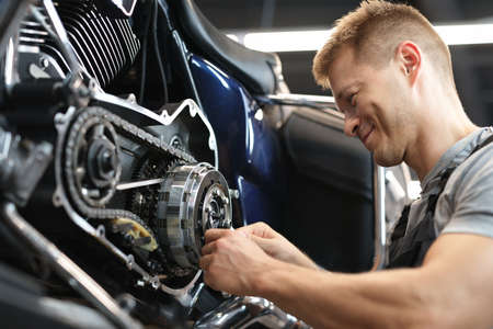 Male mechanik repair motorcycle in special service portrait.