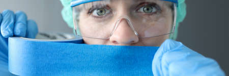 Woman doctor sealing her mouth with blue tape