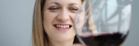 Portrait of young woman with glass of red wine in her handの写真素材