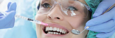 Doctor gives woman an anesthetic injection closeup