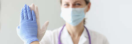 Two doctors in protective masks and gloves give each other fiveの写真素材