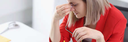 Tired woman at working table in office