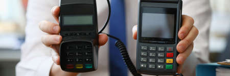 Businessman holding different pos terminals in his hands closeupの写真素材