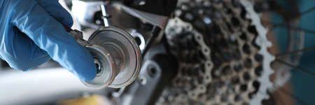 Foreman in gloves putting stethoscope on broken bike closeupの写真素材