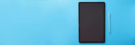 Modern touch tablet with stylus lies on blue backgroundの写真素材