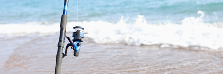 Fishing rod for catching fish stands on coastline of seaの写真素材