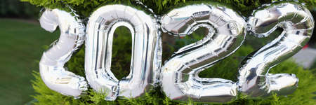 Number 2022 of silver helium balloons hanging on christmas tree closeupの写真素材