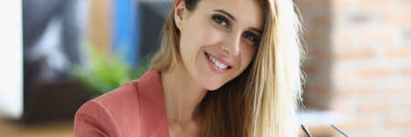 Portrait of smiling blonde businesswoman at workplaceの写真素材