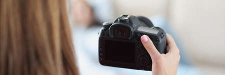 Black modern camera in female hand closeupの写真素材
