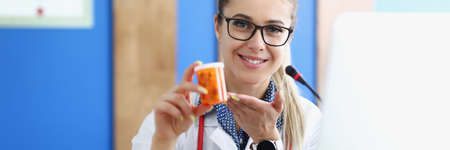 Woman doctor holding jar of capsules in her hands clinicの写真素材