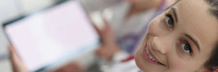 Women doctors sitting with digital tablet in handsの写真素材