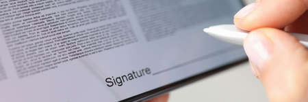 Person puts signature with stylus on contract screen of smartphoneの写真素材