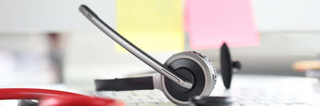 Stethoscope with headphones and microphone lie on computer keyboardの写真素材