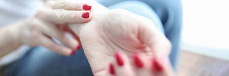 Woman holds fingers on artery and conducts pulse controlの写真素材