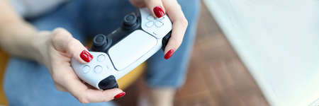 Silver game joystick in female hands closeup