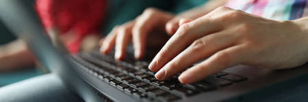 Female hands are typing on laptop keyboardの写真素材
