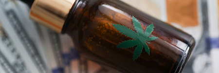 Bottle of marijuana oil lies on banknotesの写真素材