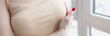 Woman hand examining mammary gland at home closeupの写真素材