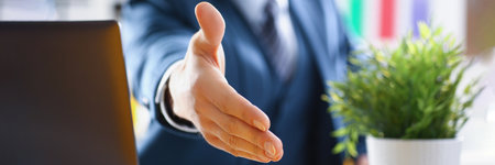 Man in business suit stretching out his hand for handshake closeupの写真素材